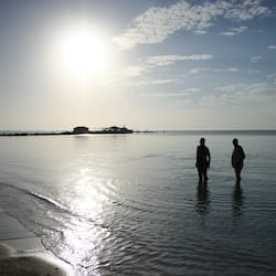 En la playa, arena blanca, sillas reclinables de playa, toallas de playa