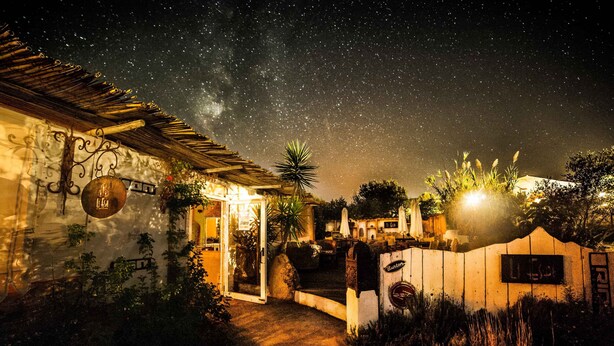 A rustic building with a starry night sky, a wooden fence, and a sign that reads "Burton." - AgriRistoChic Resort Li Espi (Palau)