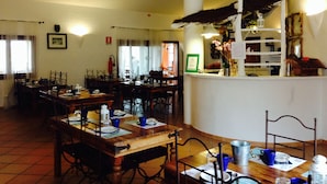 A restaurant with multiple dining tables, chairs, and a bar area. - AgriRistoChic Resort Li Espi (Palau)