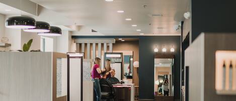 A modern interior with a reception desk, seating area, and a counter.