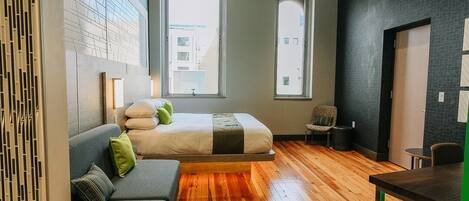 Une chambre moderne équipée d’un lit, d’un canapé, d’un bureau et de deux fenêtres.