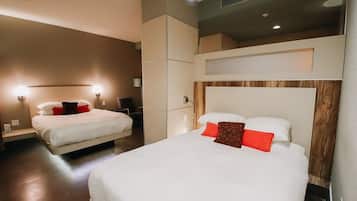 A hotel room with two beds, a wooden headboard, and a built-in wardrobe.