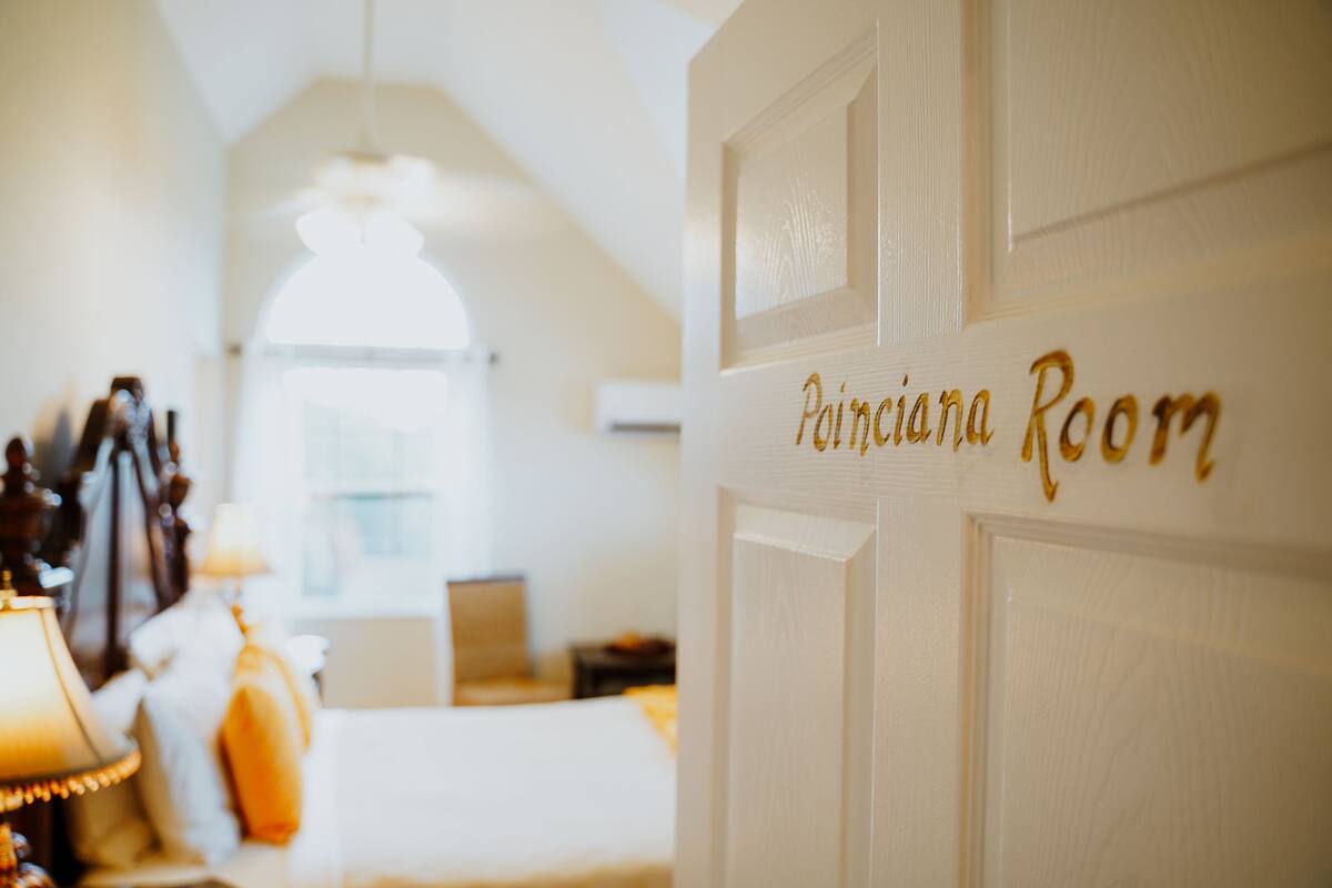 Habitació amb un senyal que diu "Pianissima Room" a la porta, una làmpada i un llit al fons.