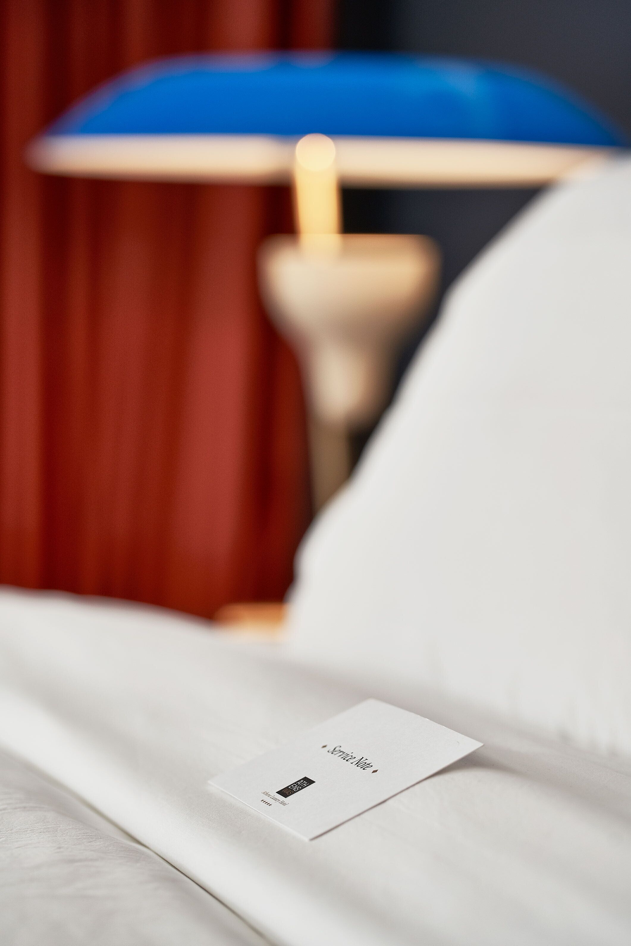 Ein ordentlich gemachtes Bett mit einem weißen Kissen und einer kleinen Karte darauf.