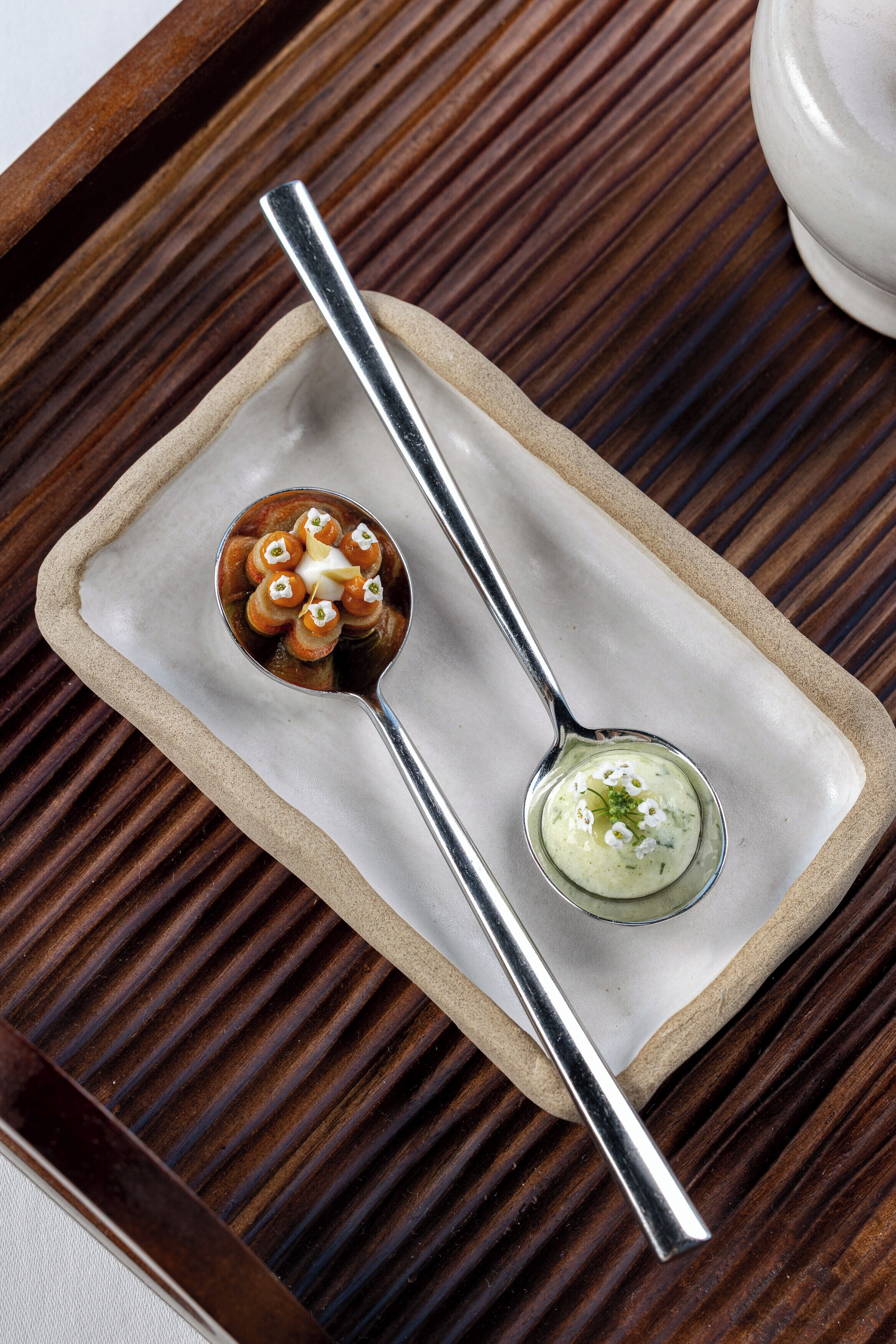 A dessert with a spoon on a wooden tray.