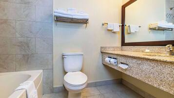 Un baño moderno con bañera, inodoro y zona de lavamanos.
