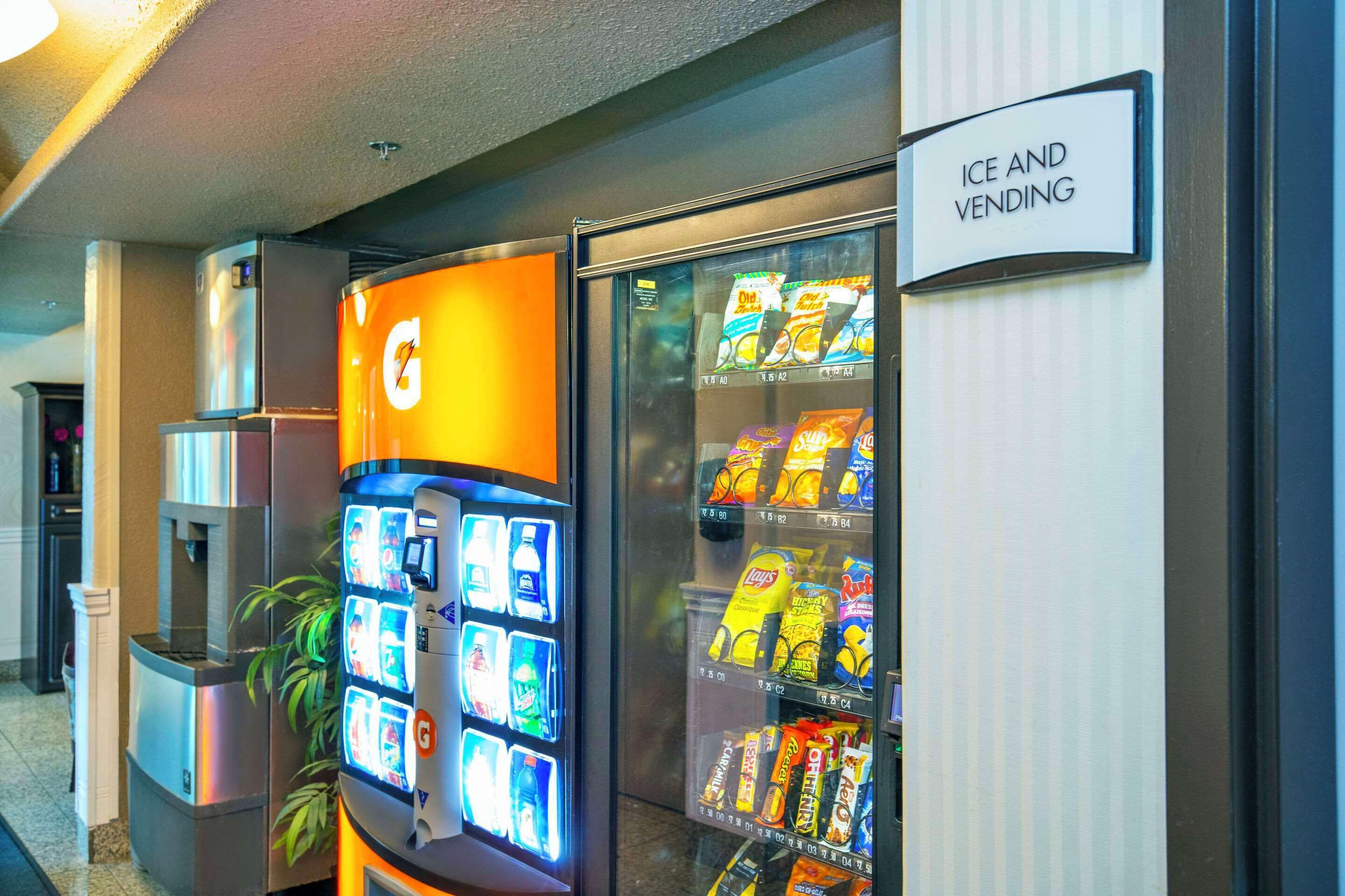 A vending machine and an ice and vending machine in a hotel lobby.