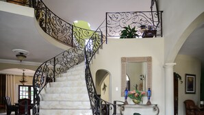 A grand staircase with ornate metal railings and a marble finish, leading to an upper floor. - Khastle Khodero (Montego Bay)