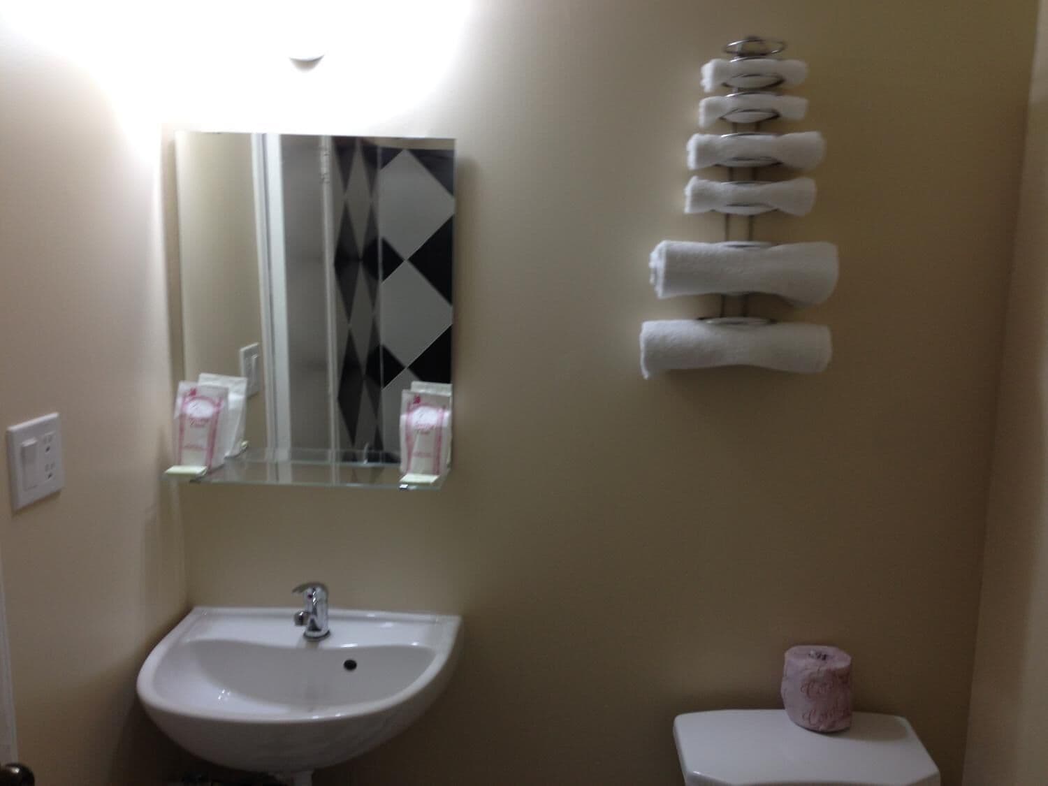 Un baño con lavabo, espejo e inodoro.