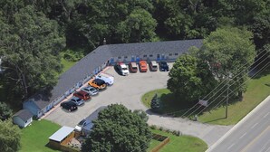 Vista aérea de un estacionamiento con varios autos y un edificio con puertas azules.