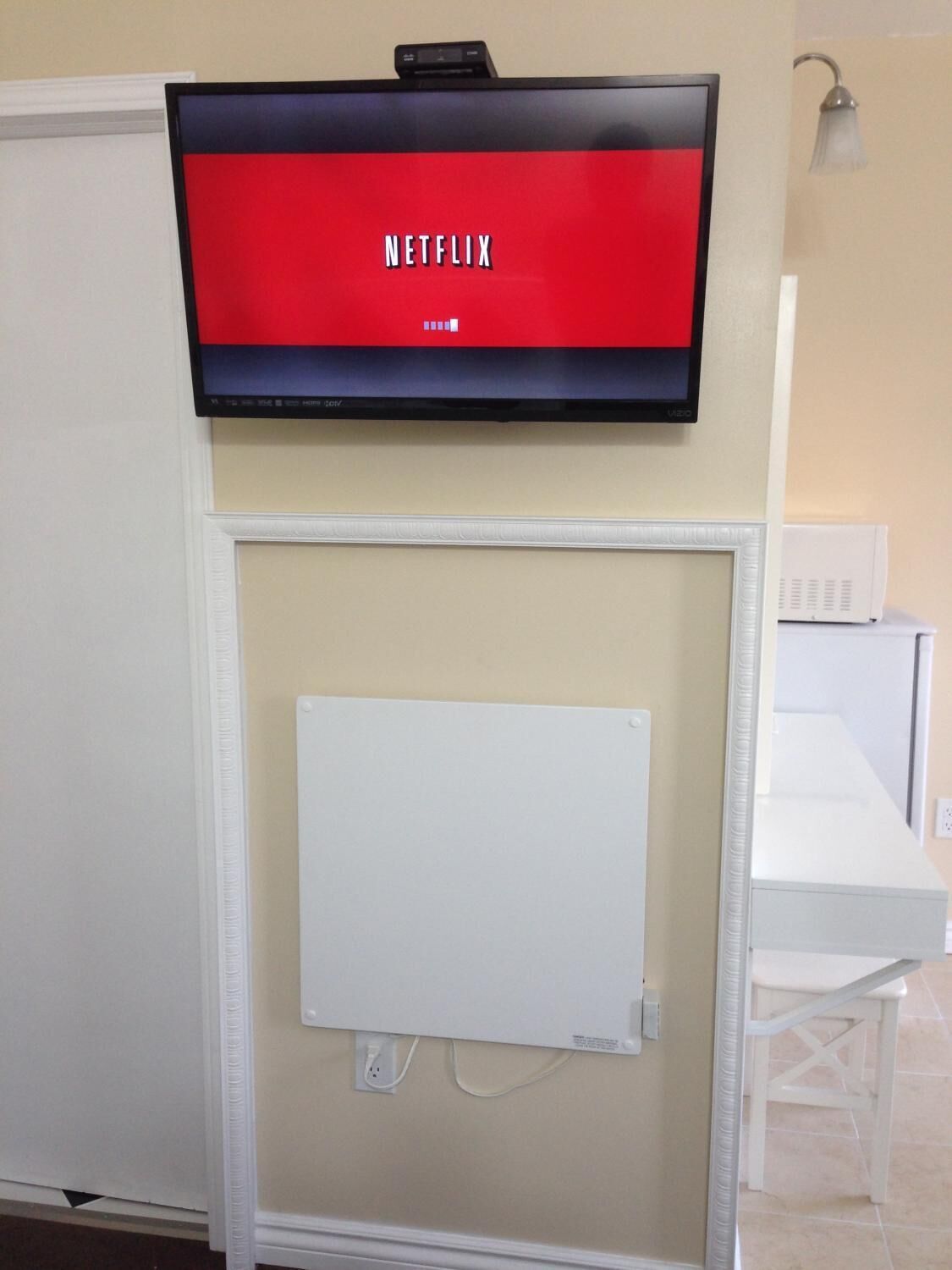 Un televisor montado en la pared mostrando el logotipo de Netflix.