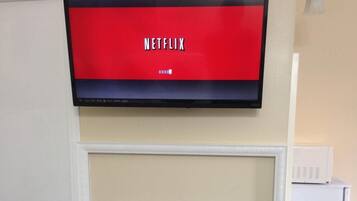 Un televisor montado en la pared mostrando el logotipo de Netflix.