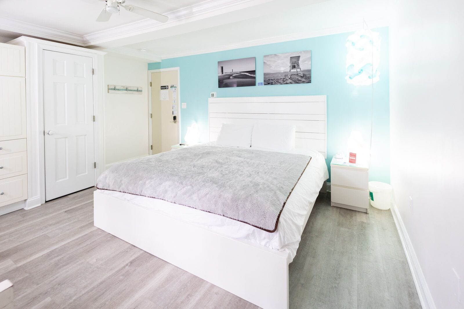 Un dormitorio con cama, mesita de noche, armario y puerta.