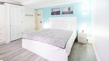 Un dormitorio con cama, mesita de noche, armario y puerta.