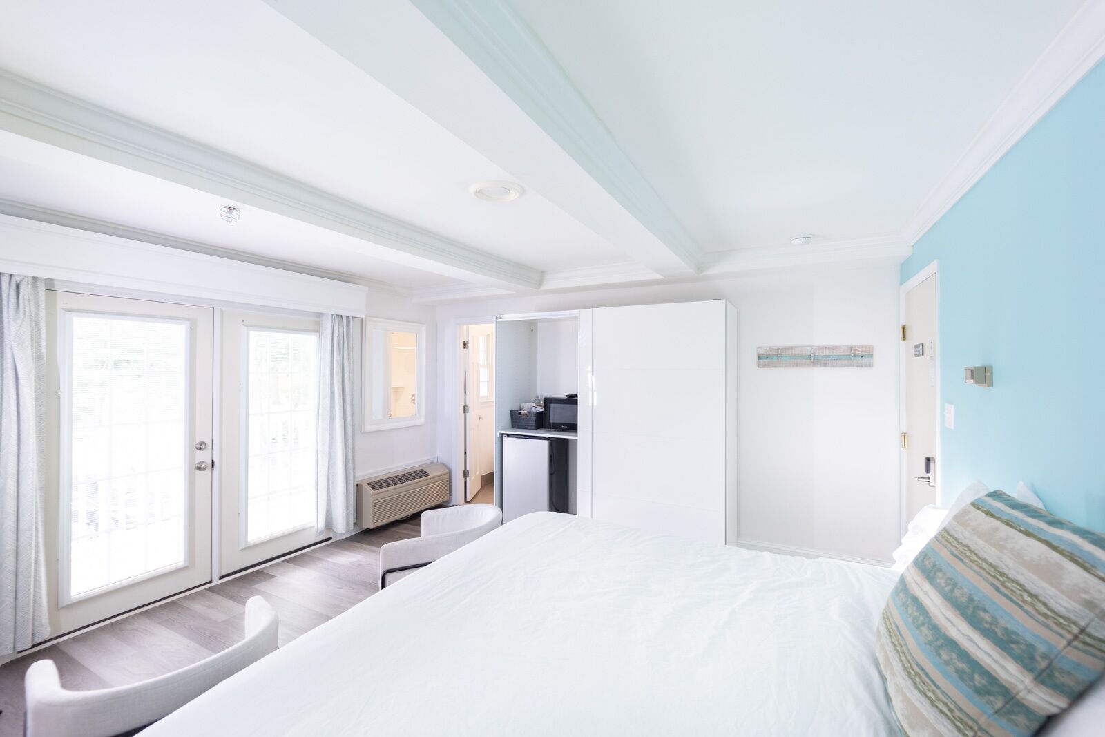 Habitación de hotel con una cama grande, un escritorio con computadora, una ventana con cortinas y vistas al exterior.