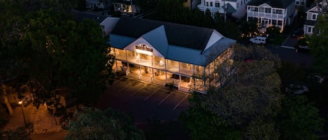 An aerial view of a hotel with a large parking lot, multiple floors, and a prominent entrance with a covered area.