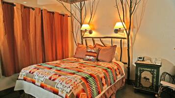 A cozy bedroom with a bed, two wall-mounted lamps, a nightstand, and a decorative wall piece.