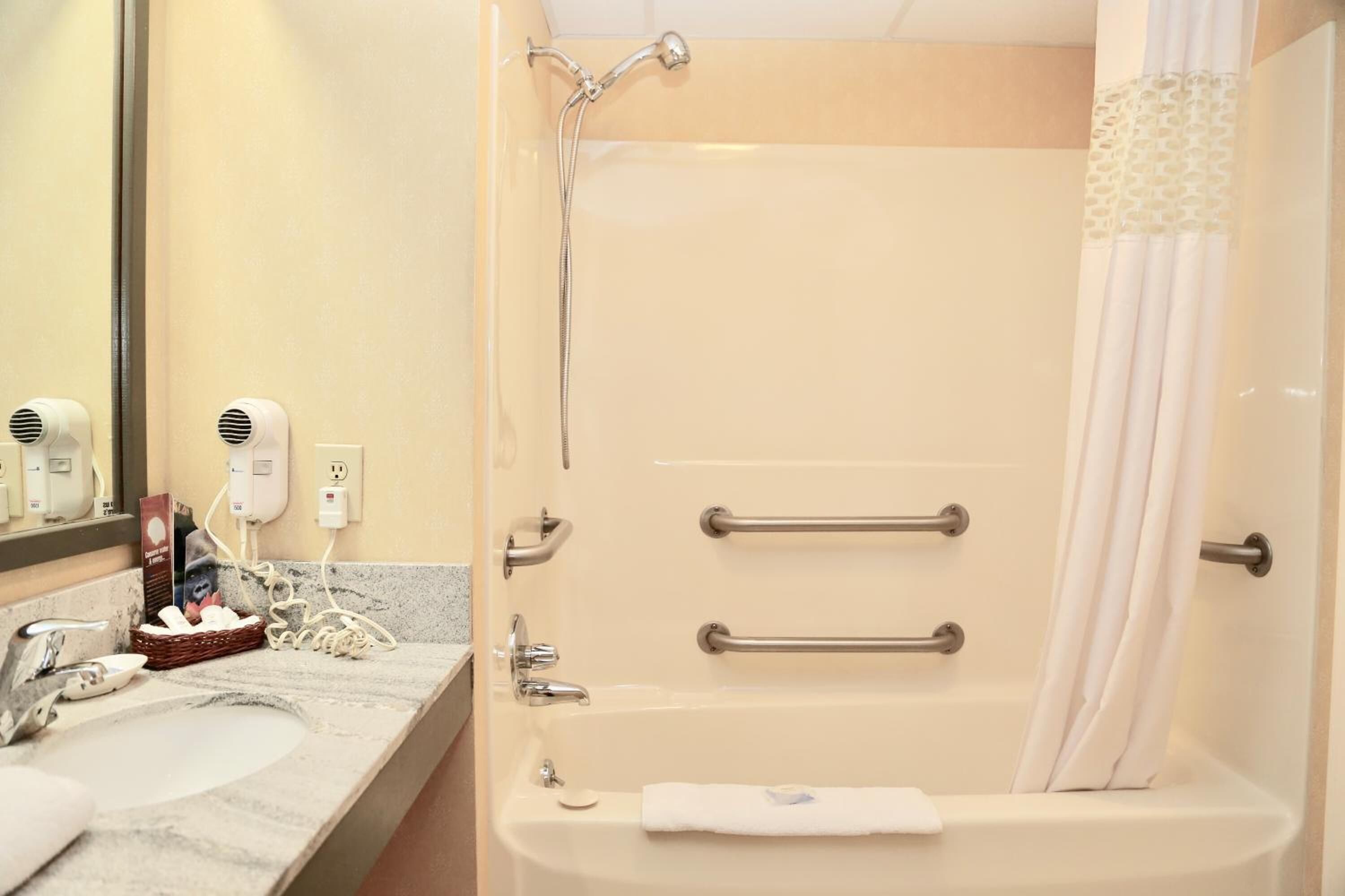 A bathroom with a bathtub, a sink, and a mirror.