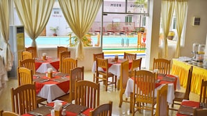 Un restaurante con varias mesas, cada una cubierta con manteles rojos y sillas de madera.