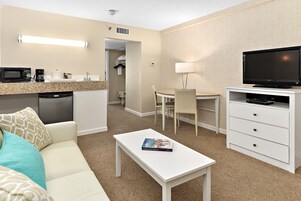 Une chambre d’hôtel équipée d’une kitchenette, d’un coin repas, d’une télévision et d  ’un lit.