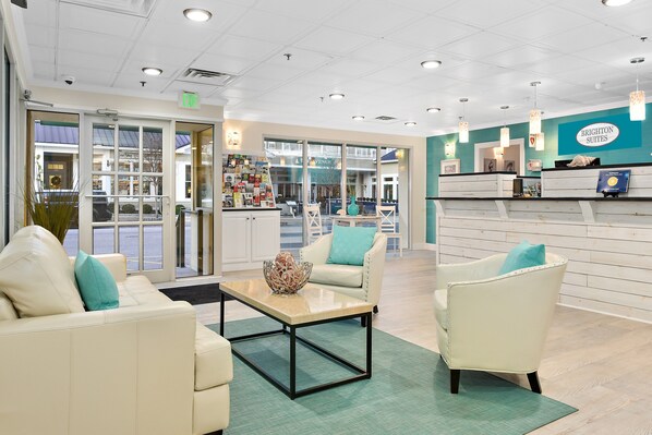 A reception area with a seating arrangement, a reception desk, and a view of the outside.