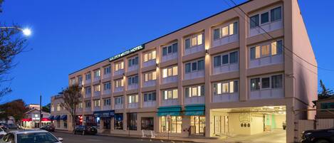 A multi-story hotel with a flat facade, multiple balconies, and a ground-level entrance.