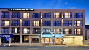 A multi-story hotel with a sign reading "Brighton Suites Hotel". - Brighton Suites Hotel (Rehoboth Beach)