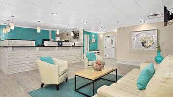 A reception area with a counter, seating, and a wall-mounted TV.