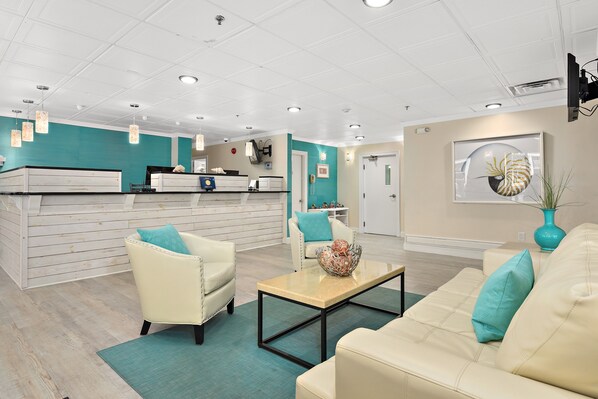 A reception area with a counter, seating, and a wall-mounted TV.