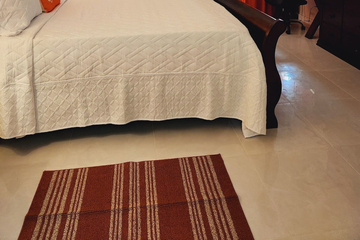 Une chambre d’hôtel équipée d’un lit, d’un bureau, d’une chaise, d’une télévision et d’une porte coulissante donnant sur le balcon.