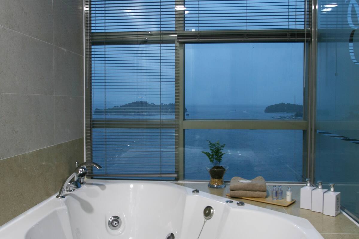 premier family room, ocean view | deep-soaking bathtub