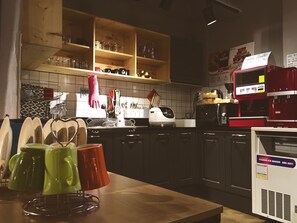 A kitchen with wooden shelves, a coffee machine, and a refrigerator. - Suncheon Guesthouse Nreem (Suncheon)