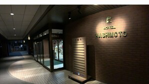 A hotel entrance with a sign reading "HOTEL HASHIMOTO" and a reception desk. - Hotel Hashimoto (Sapporo)
