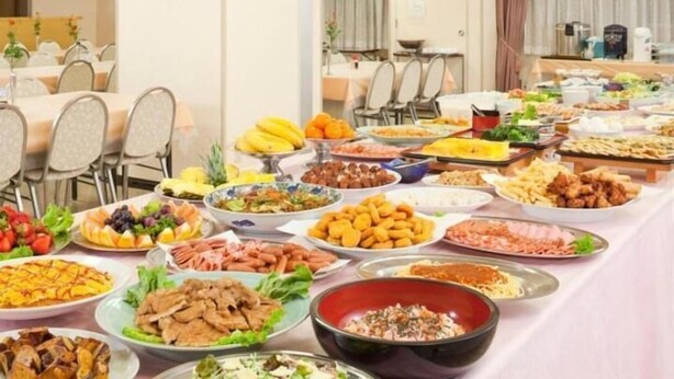 A buffet table with various dishes and a dining area with chairs and tables. - Hotel Hashimoto (Sapporo)
