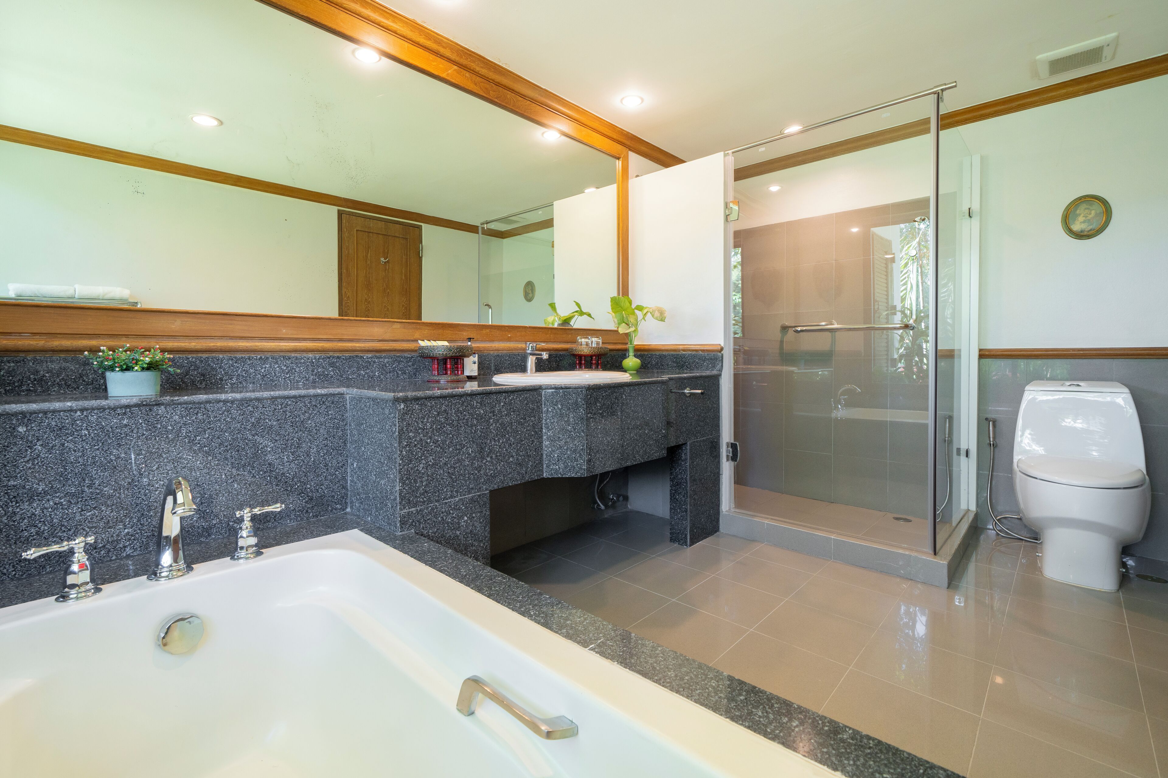 Ein modernes Badezimmer mit einer großen Badewanne, einer gläsernen Dusche und einer Toilette.