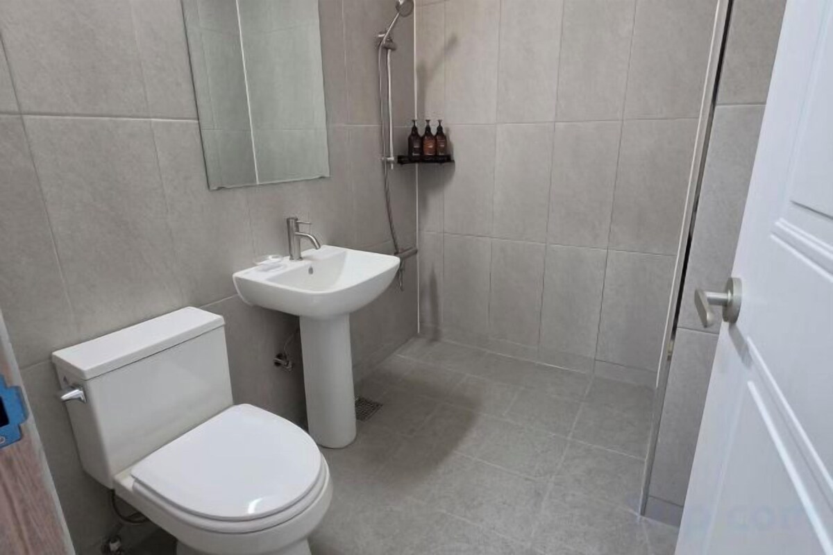 A bathroom with a toilet, sink, and shower.