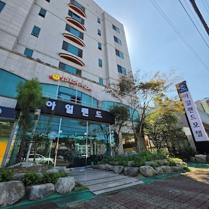A hotel with a modern facade, large windows, and a sign indicating it is the Island Hotel.