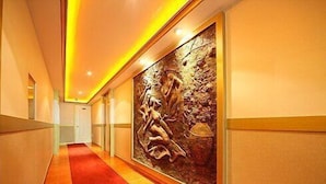 Un pasillo con alfombra roja, un mural grande en la pared y diseño de paneles de madera.
