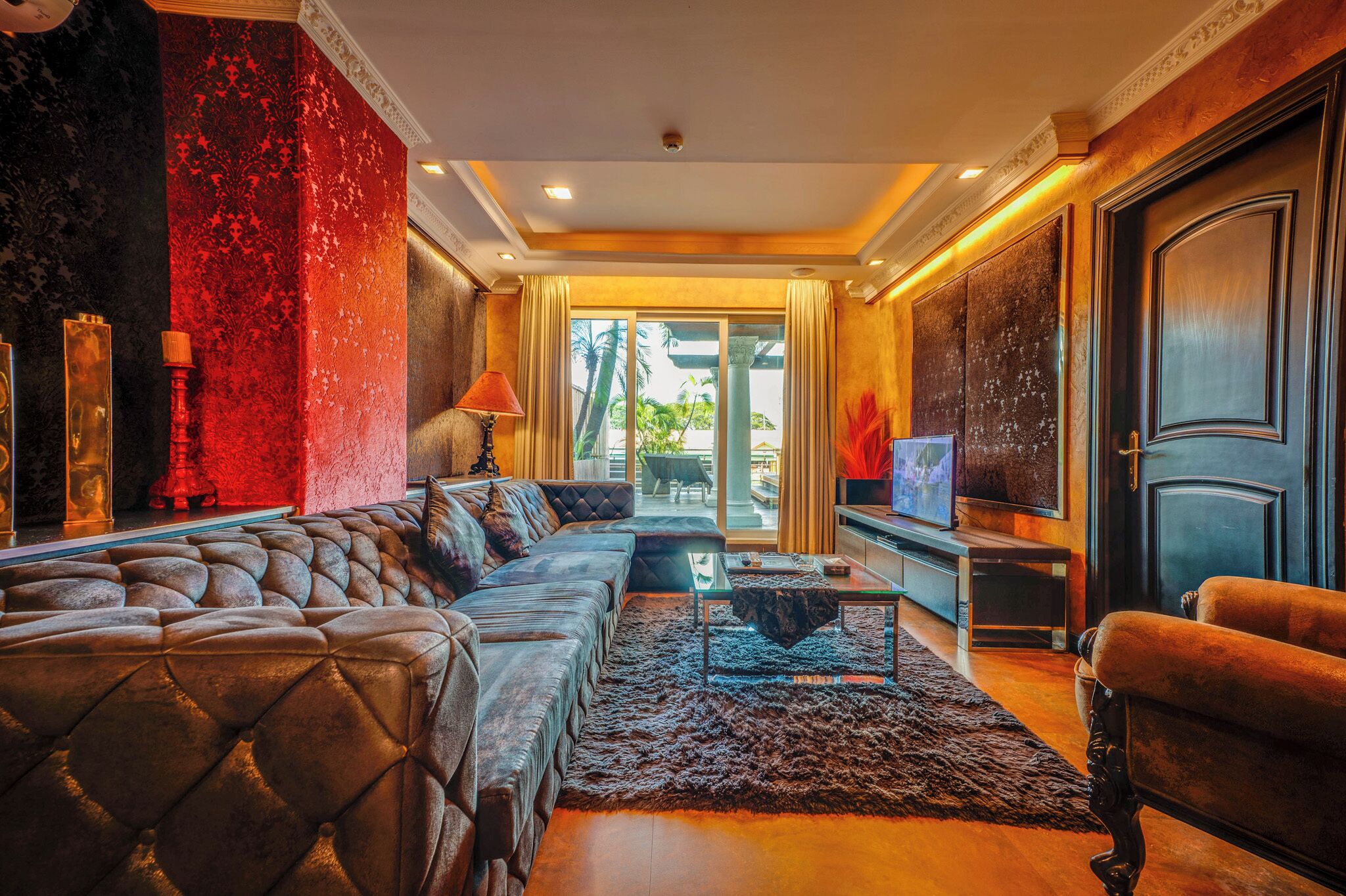 A luxurious living room with a plush sofa, a coffee table, and a television.