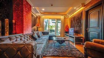 A luxurious living room with a plush sofa, a coffee table, and a television.