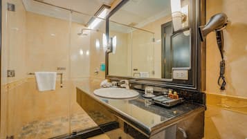 Un baño moderno con un espejo grande, un lavamanos, un secador de pelo y un perchero para toallas.