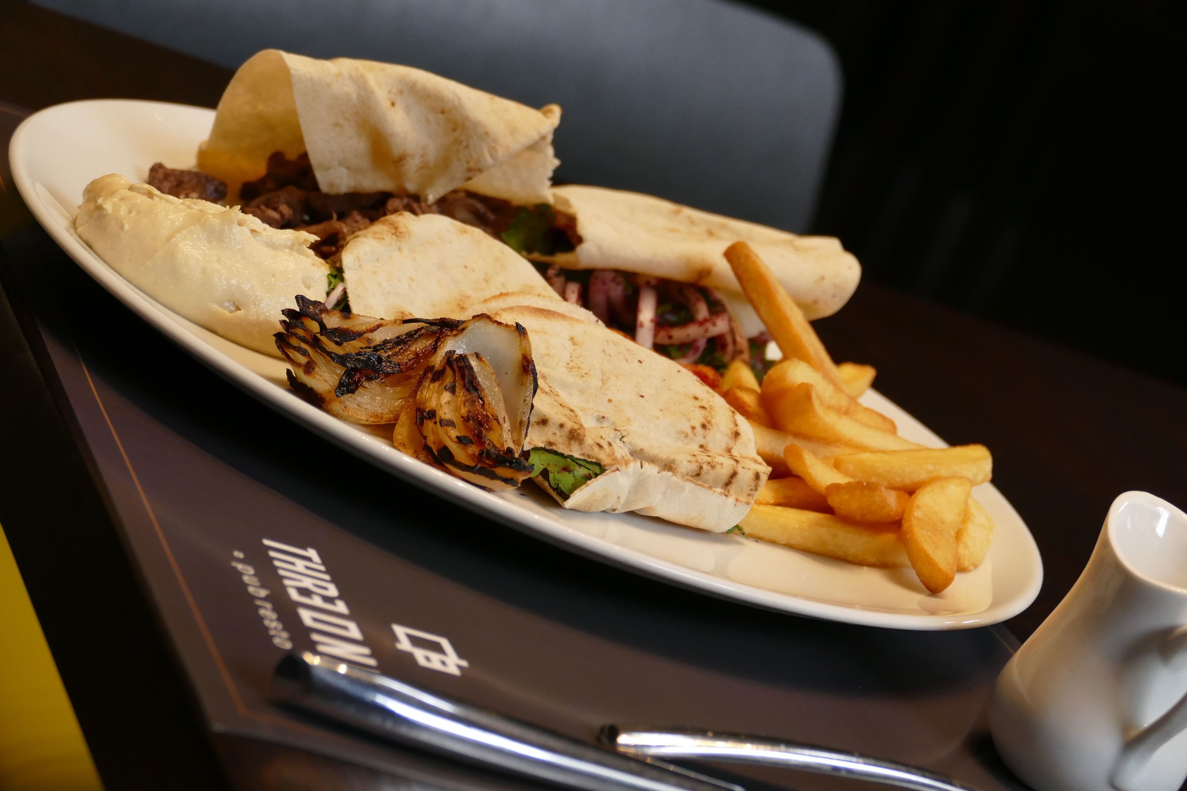 Un plato de comida con un sándwich y papas fritas sobre una mesa.
