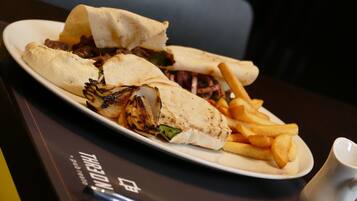 Un plato de comida con un sándwich y papas fritas sobre una mesa.