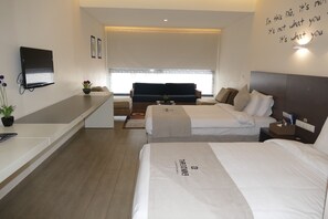 A modern hotel room with a flat-screen TV, a sofa, two beds, a bedside table, and a wall with motivational text. - Three ONine Urban House (Beirut)