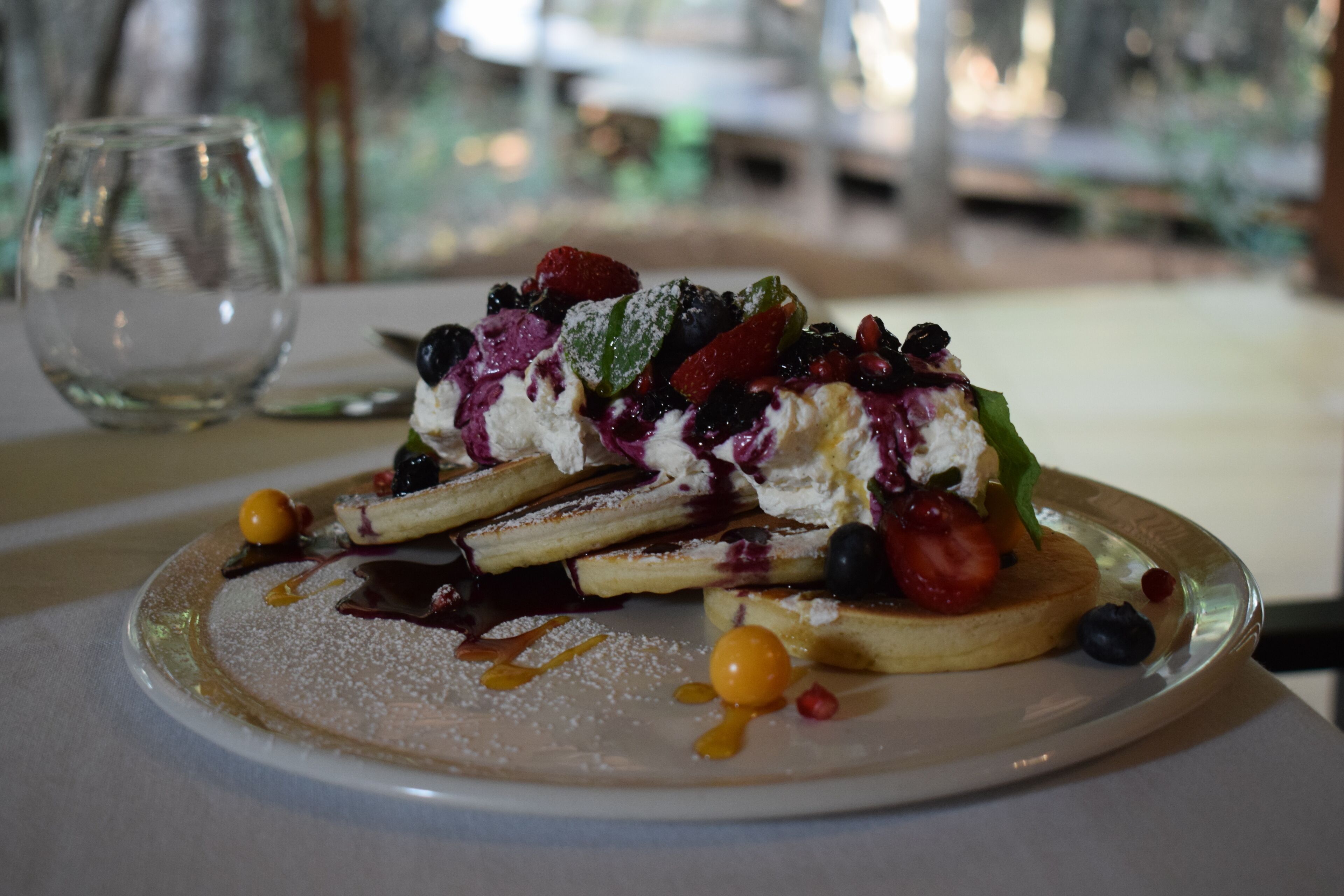 Un plato de postre con fruta y azúcar glas.