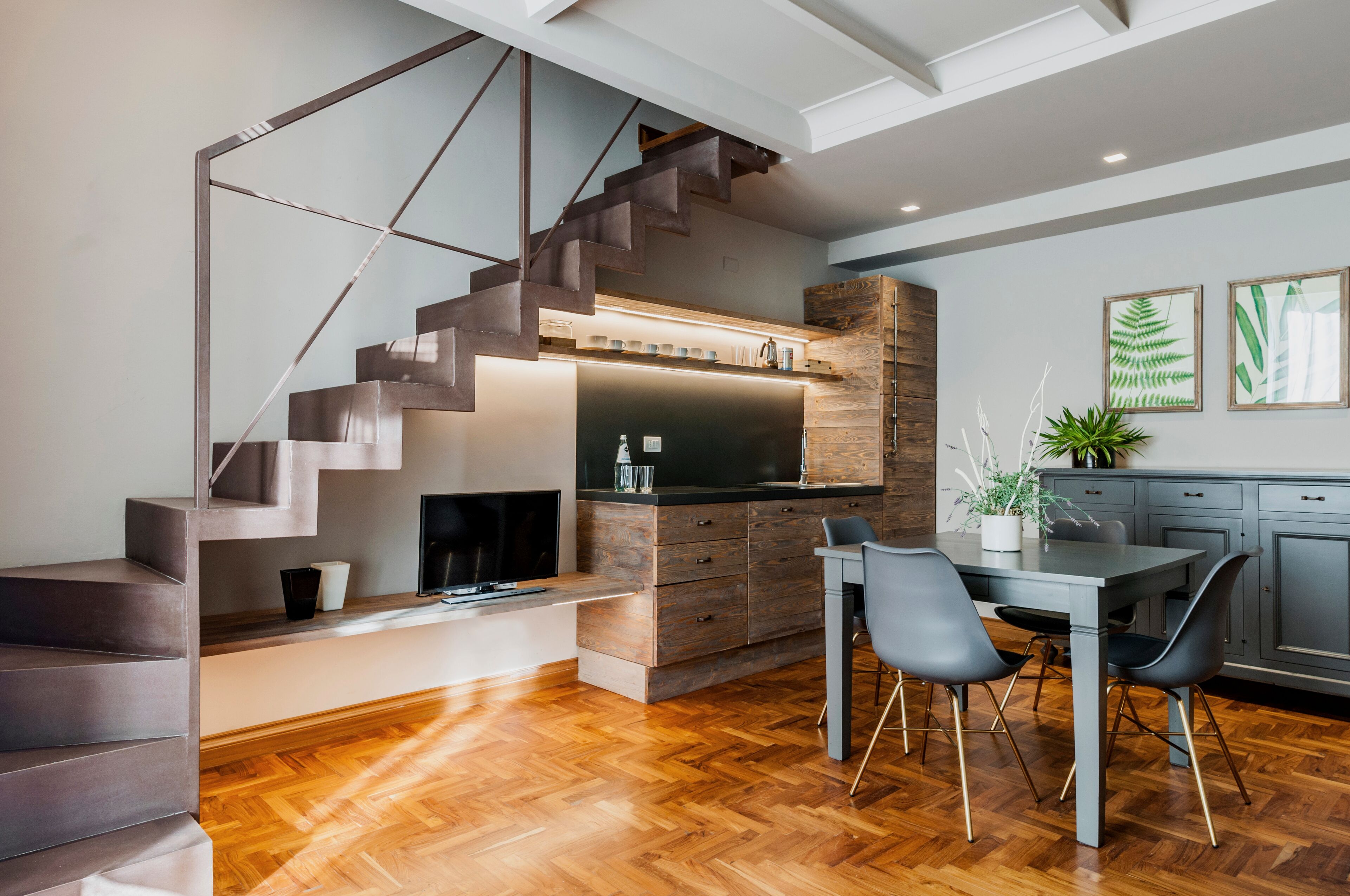 Eine moderne Küche mit Holztischplatte, eingebautem Herd und einem Essbereich mit Tisch und Stühlen.