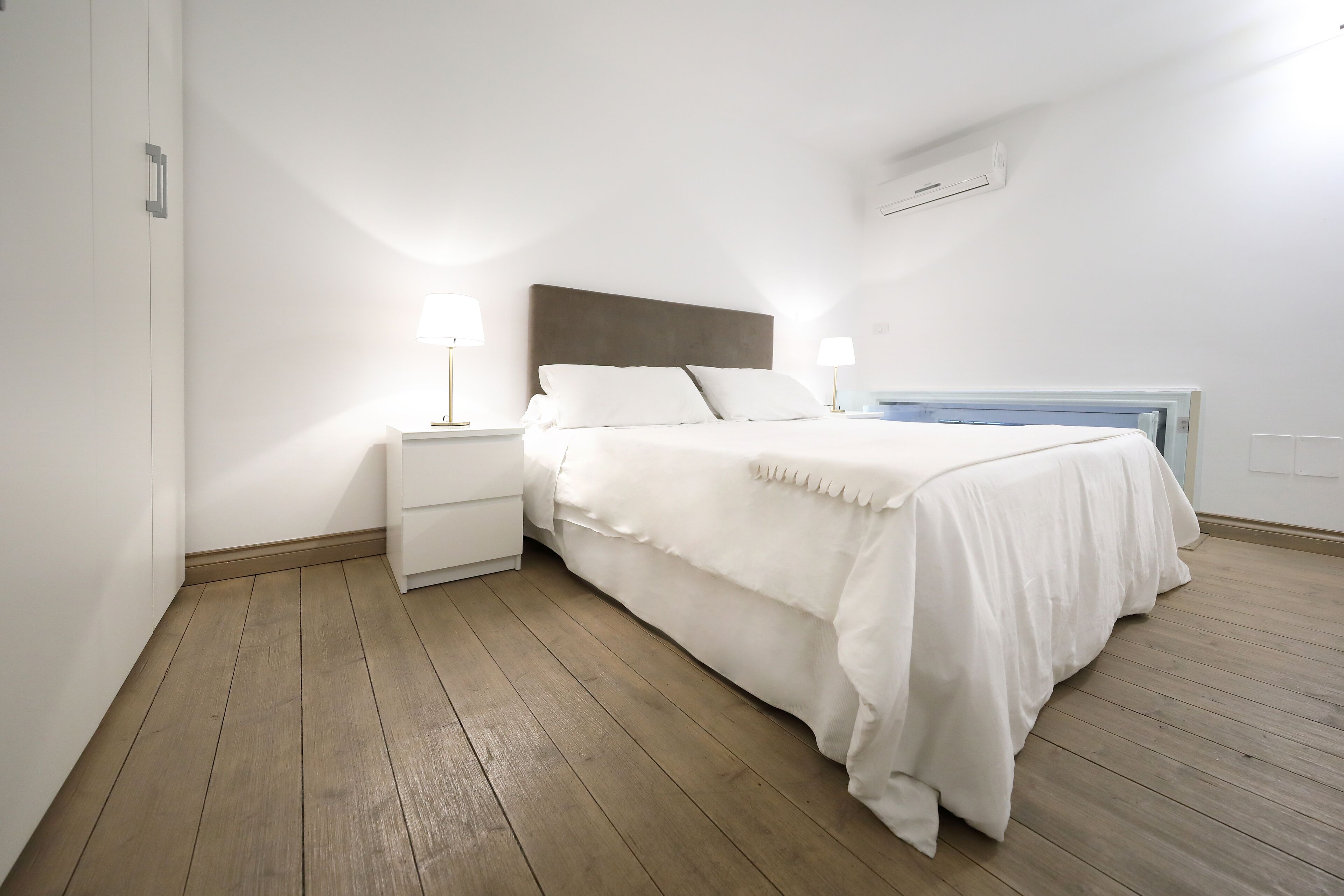 A bedroom with a bed, nightstands, and bedside lamps.
