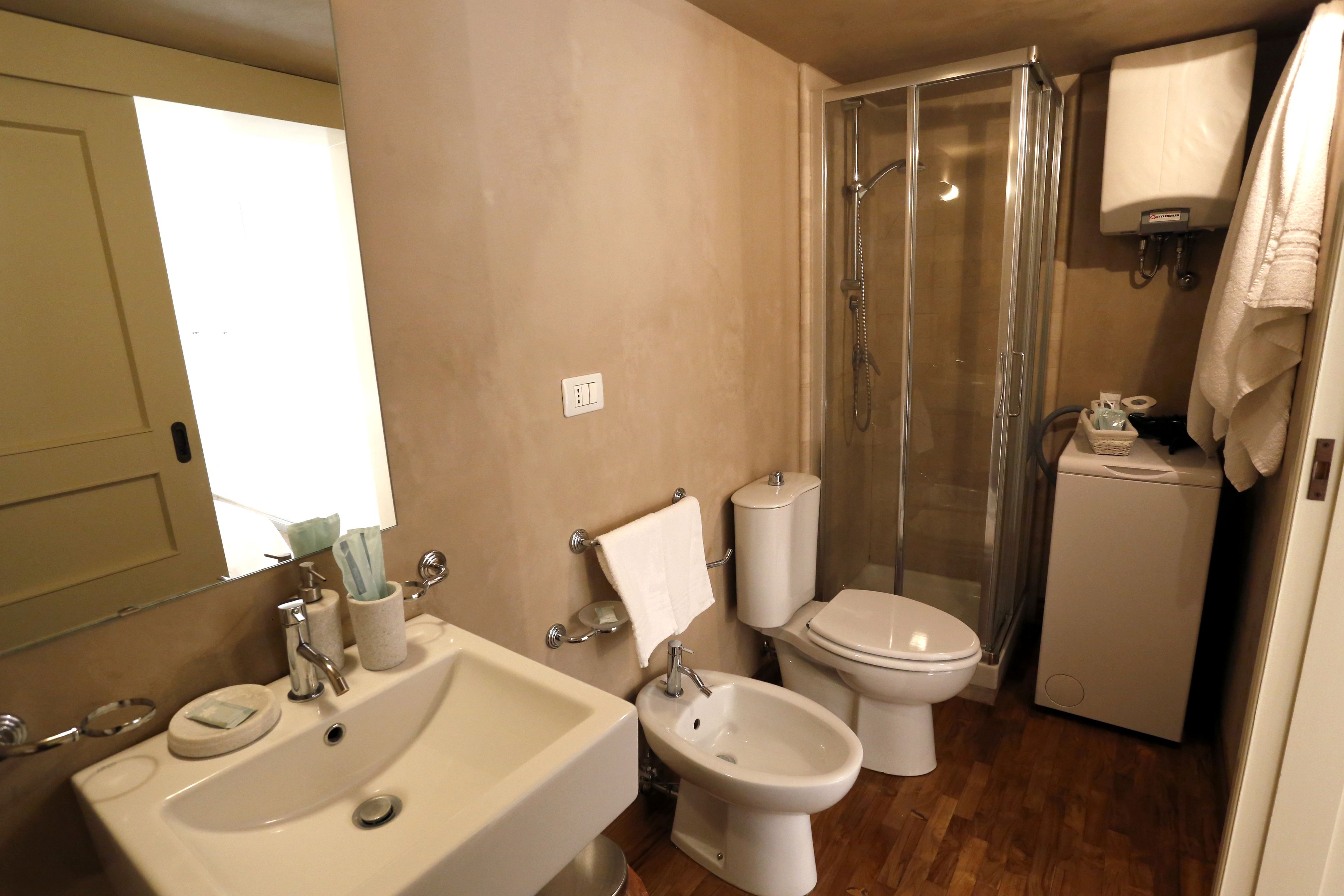 Une salle de bain équipée d’un lavabo, d’un bidet, de toilettes et d’une douche.