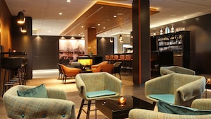 A modern lounge area with seating and a bar. - Hafenhotel Meereszeiten (Heiligenhafen)