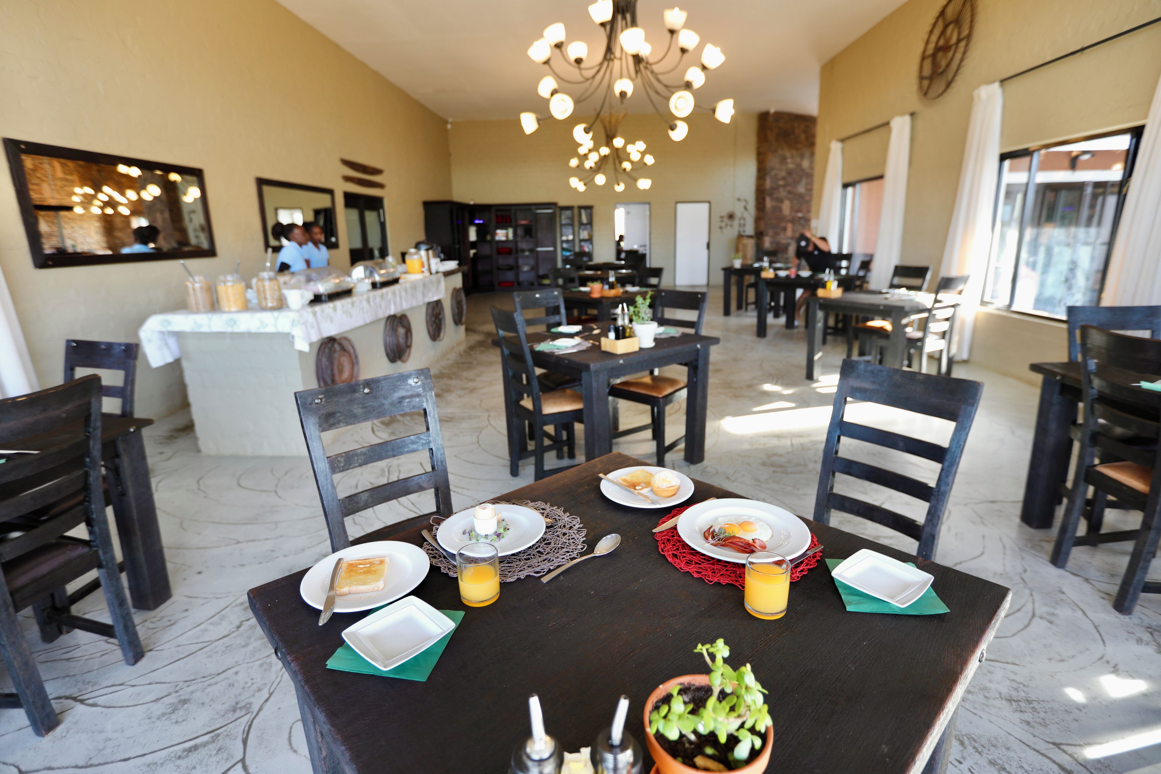 A restaurant with a central bar, multiple dining tables, and chairs.